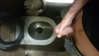 A skinny hairy guy quickly jerks off in an airport toilet
